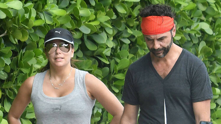Eva Longoria and husband Jose Baston take a walk along the beach in Miami.