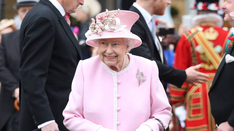 Queen elizbaeth accepts flowers from blogger at royal garden party at buckingham palace