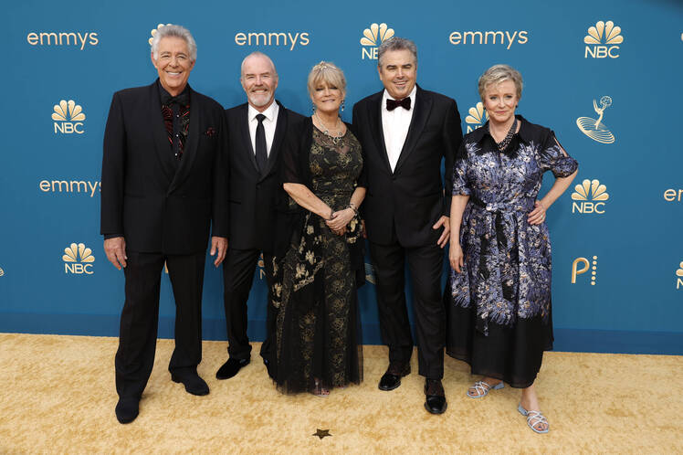 Barry Williams wears a black suit while posing with his 'Brady Bunch' costars