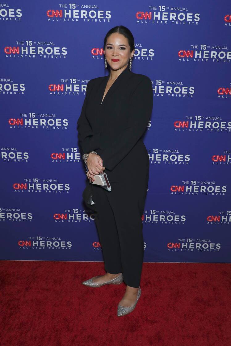 Laura Jarrett wears black pantsuit and flats