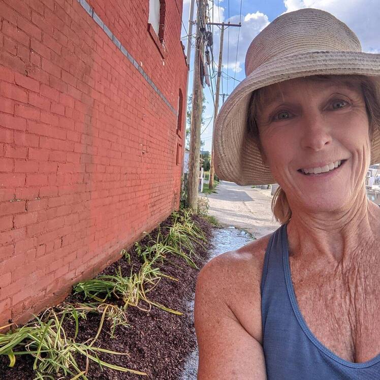 Karen E. Laine wears blue tank top and hat