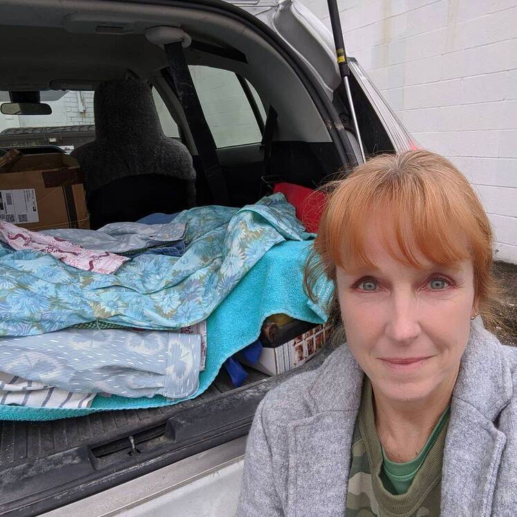 Karen E. Laine poses in front of car's trunk