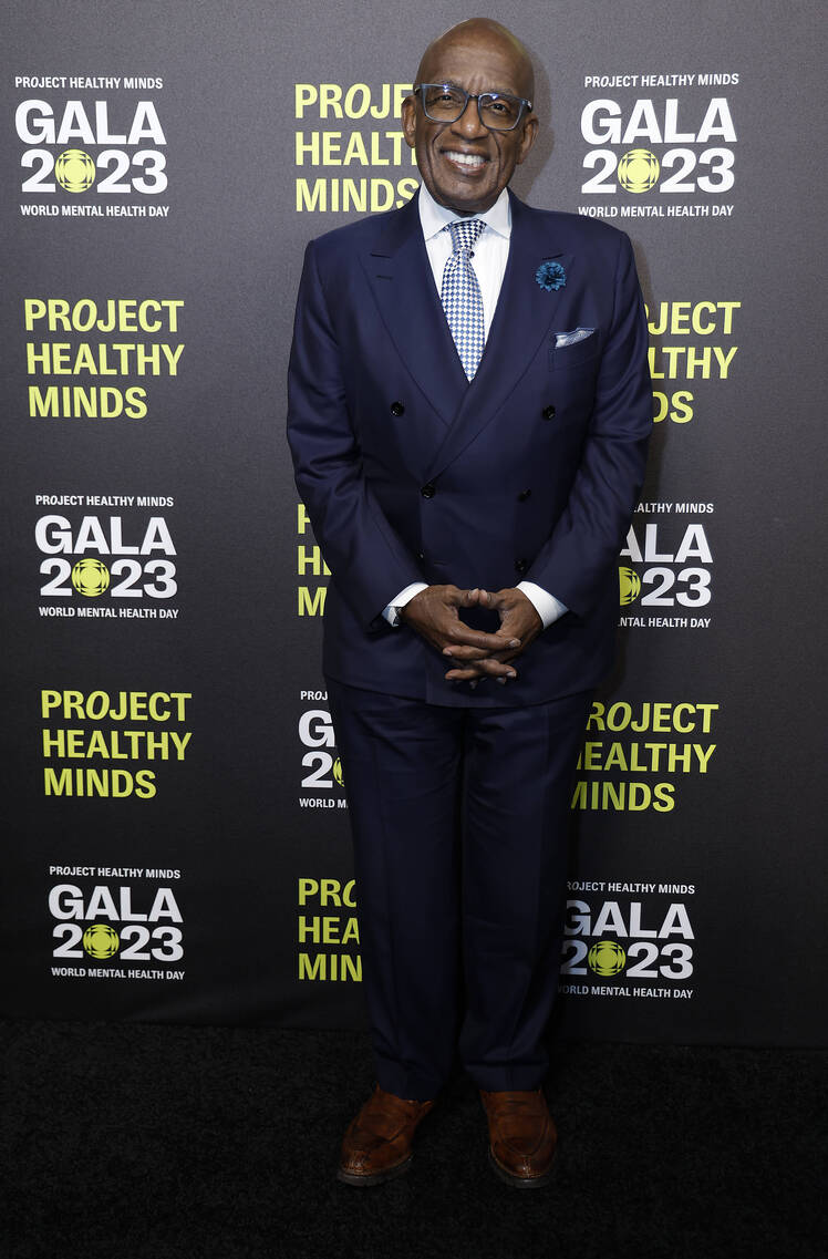 Al Roker stands with his hands crossed while wearing a dark blue suit and a blue tie