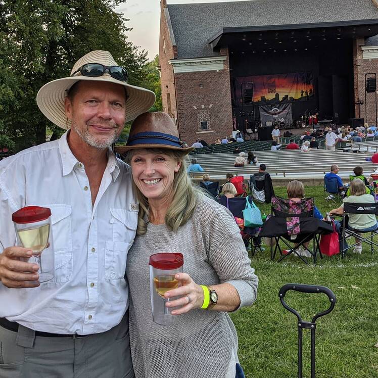 Karen E. Laine and Roger Rominger hold drinks while attending concert
