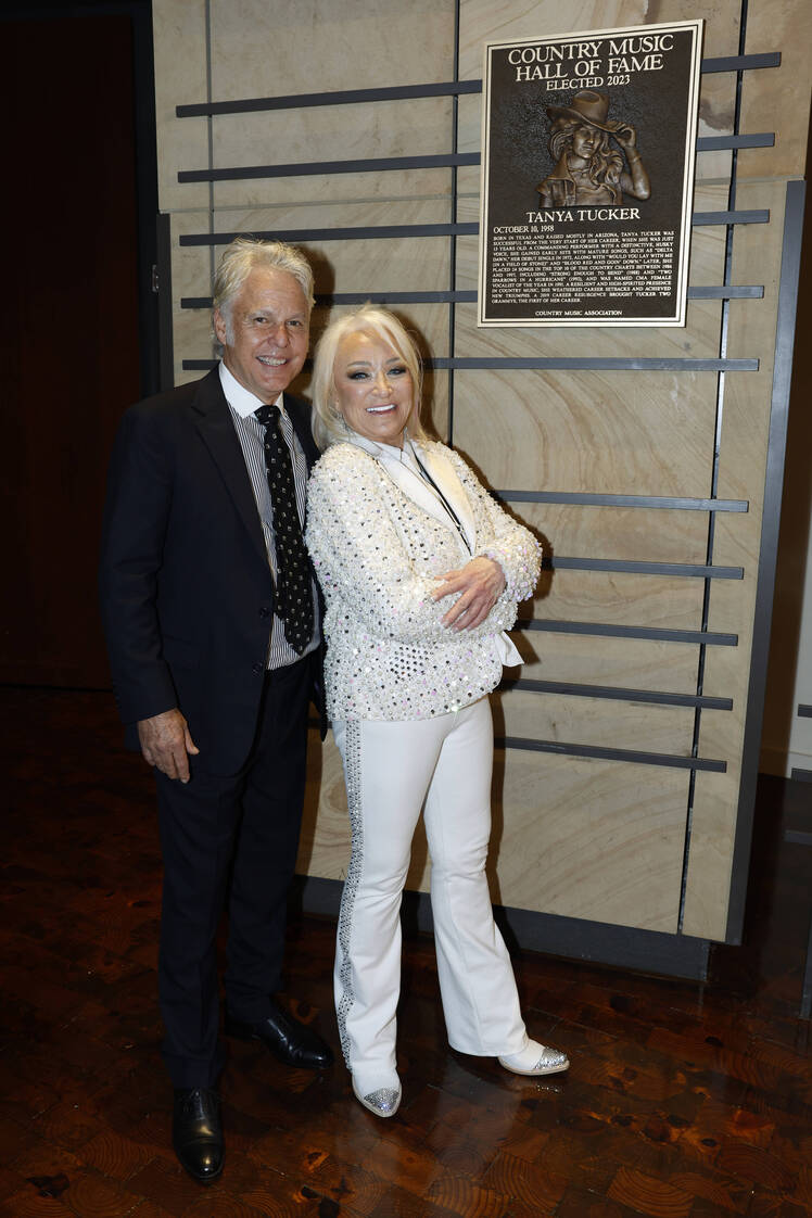 Tanya Tucker poses with her arms crossed in front of boyfriend Craig Dillingham