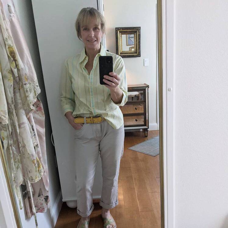 Karen E. Laine wears green shirt with jeans in mirror selfie