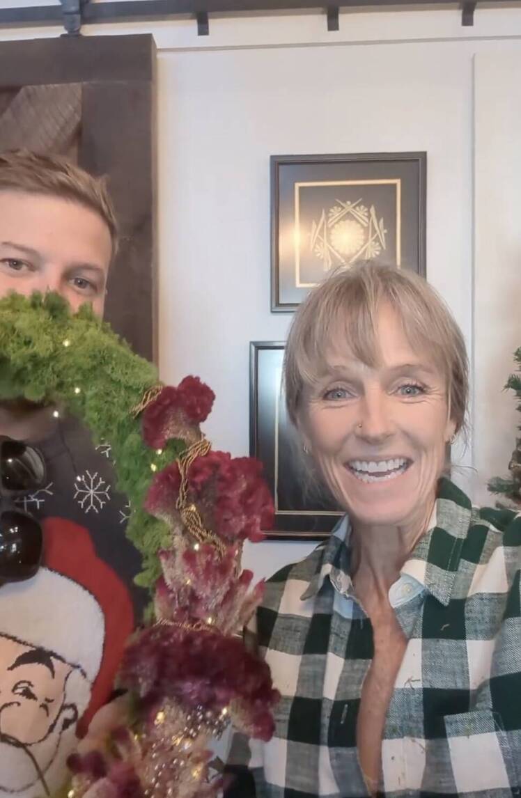 Karen E. Laine smiles while wearing a plaid shirt