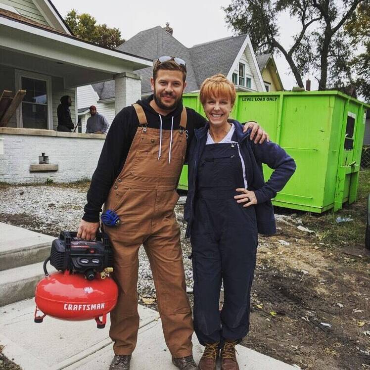 Karen E. Laine and Cory Miller wear overalls