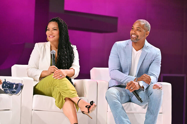 Egypt Sherrod and Mike Jackson sit in chairs on stage