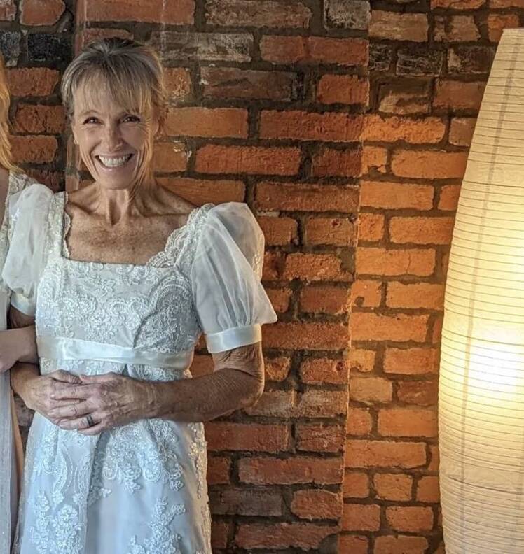 Karen E. Laine smiles in a white dress