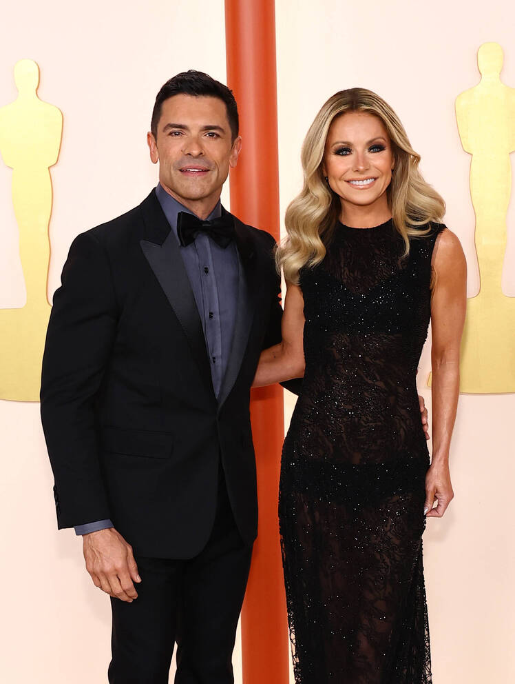 Kelly Ripa in a black dress at the Oscars with Mark Consuelos