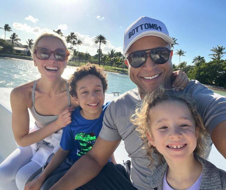 Crag Melvin sitting in front of the ocean with his family
