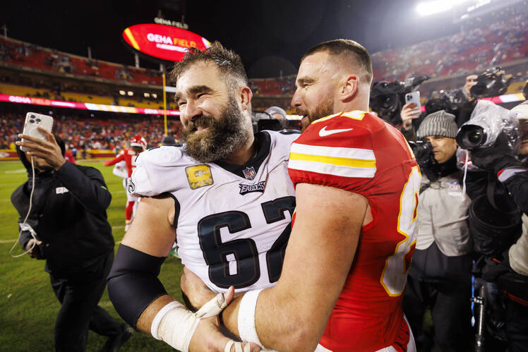 Travis Kelce and Jason Kelce hug on the field after the Chiefs took on the Eagles in November 2023.